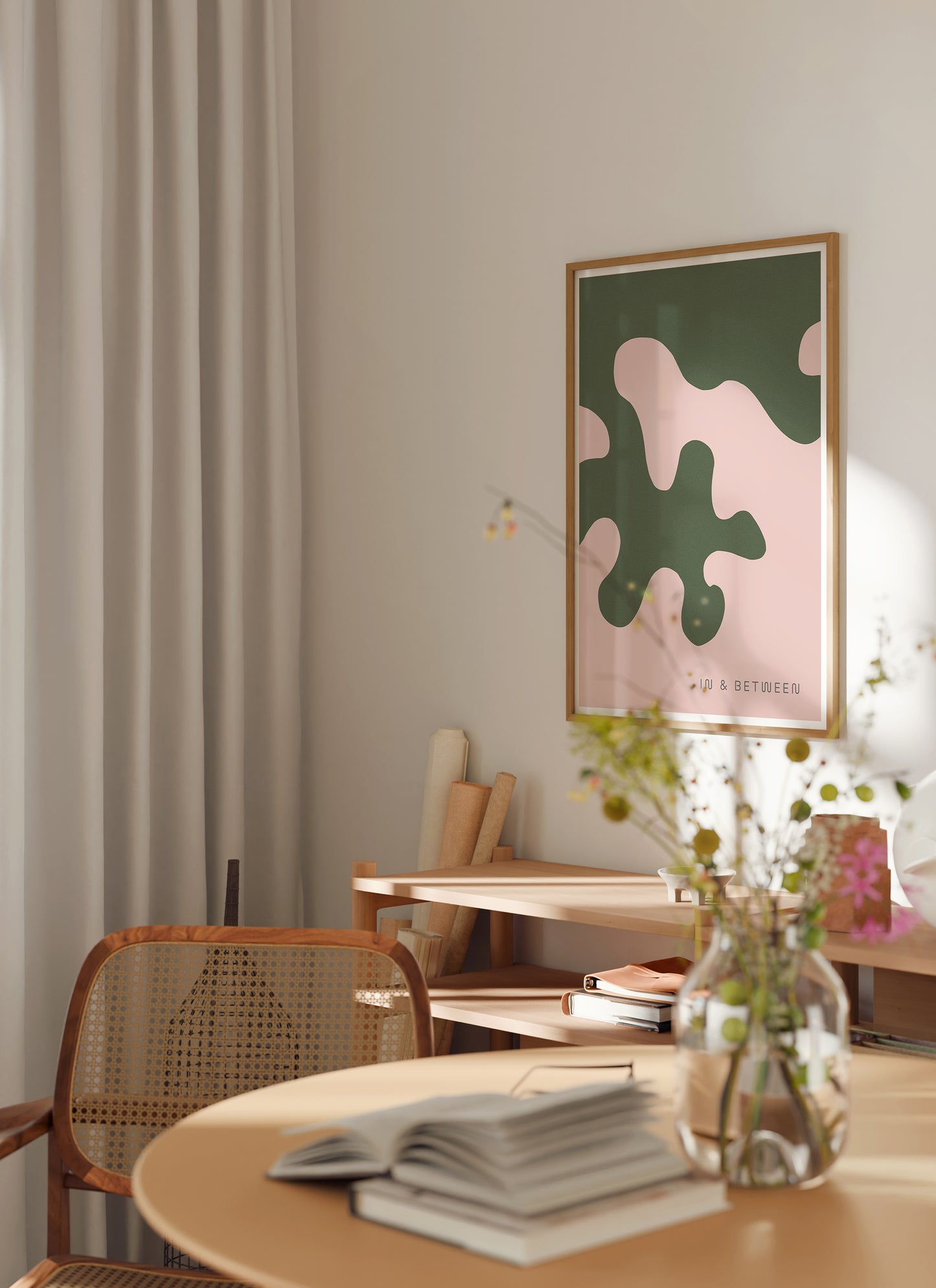 Lifestyle image with art print of large forest green oak leaf on soft peach background in natural wooden frame.