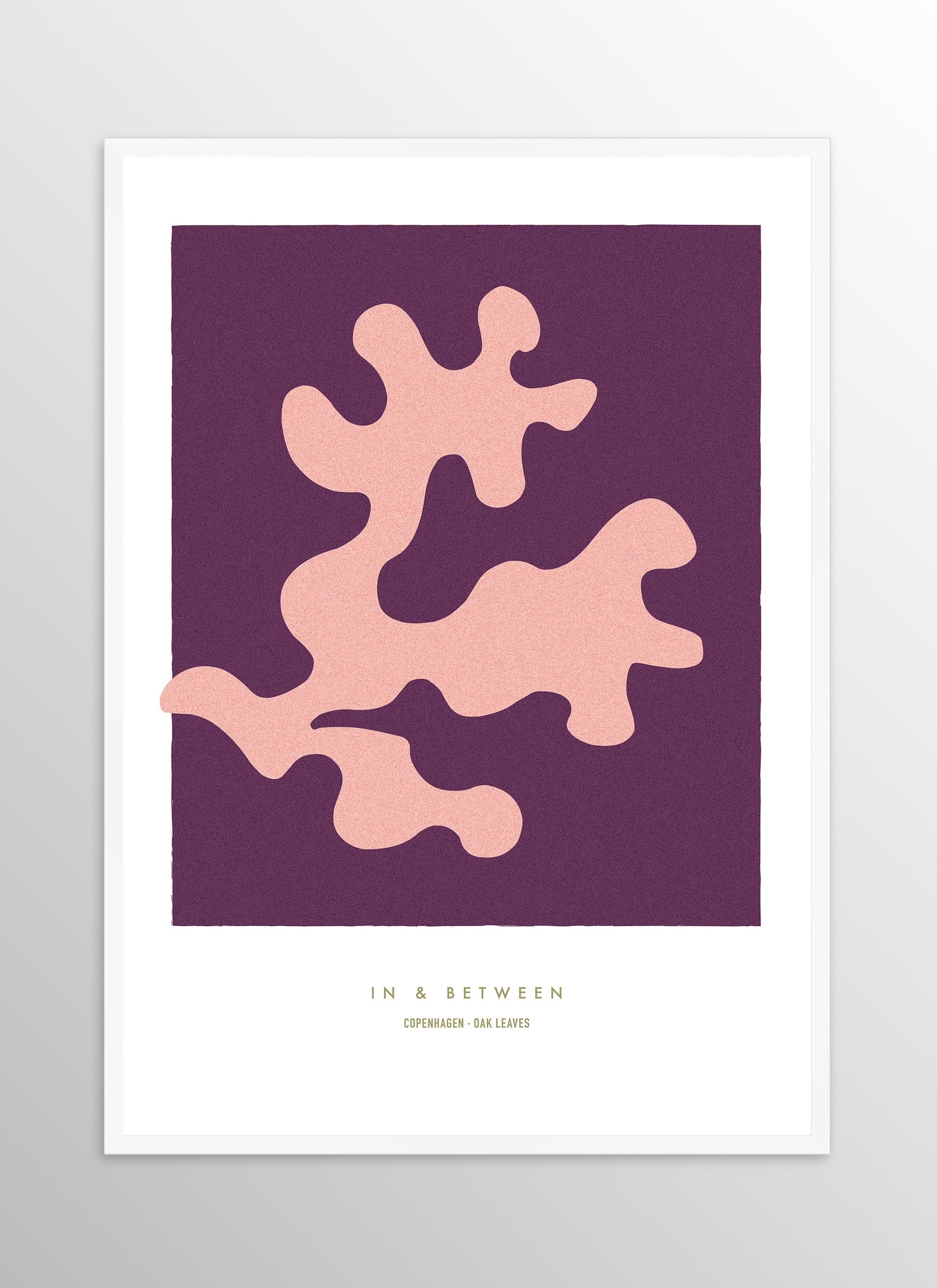 Art print of peach oak leaf on dark violet background in white wooden frame.