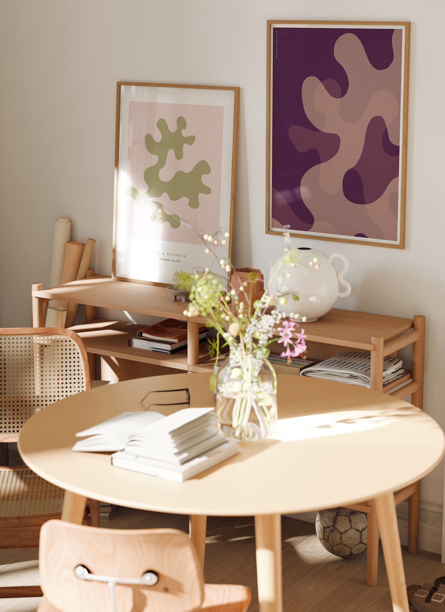 Lifestyle image with art print of large warm violet oak leaf shapes in natural wooden frame.