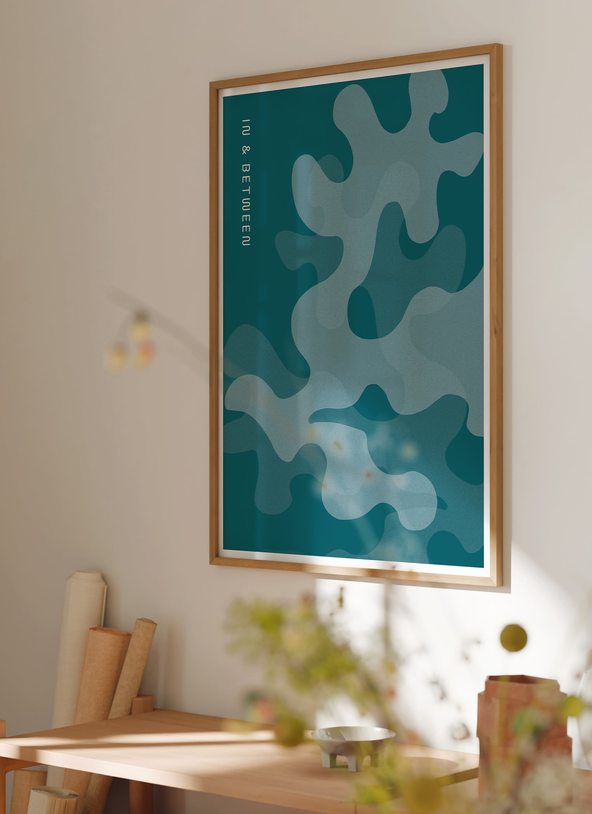 Lifestyle image with In and Between art print of oak leaves in shades of deep ocean blue in natural wooden frame.