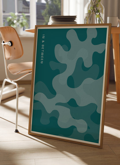 Lifestyle image with In and Between art print of oak leaves in shades of deep ocean blue in natural wooden frame.